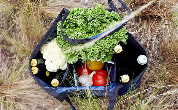 A top-down shot of The Truck filled with fresh vegetables and bottles.